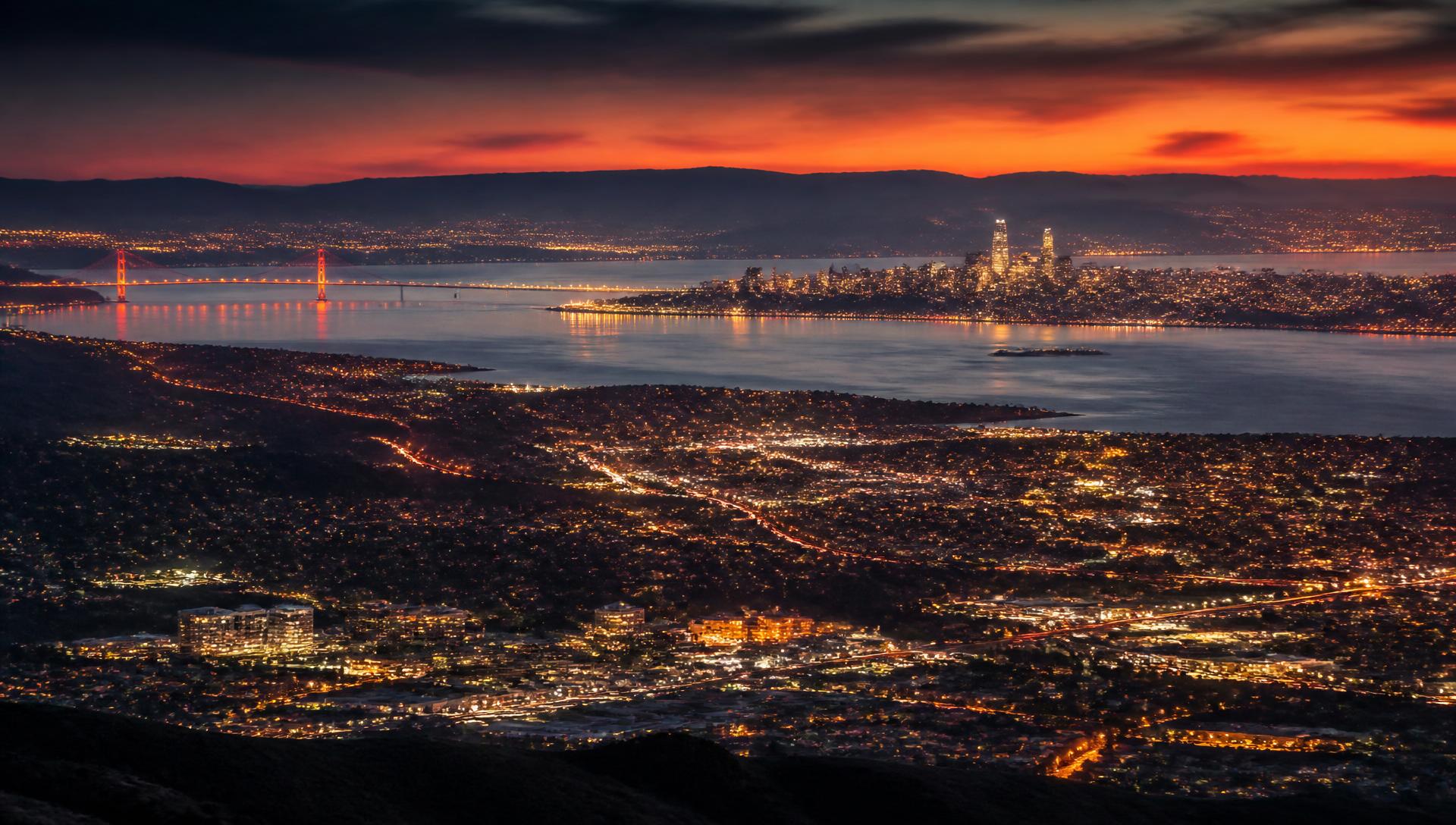 San Francisco Bay Area skyline at dusk with the Golden Gate Bridge, downtown San Francisco, and Silicon Valley city lights — Premier Executive Chauffeur service areas across 50+ cities